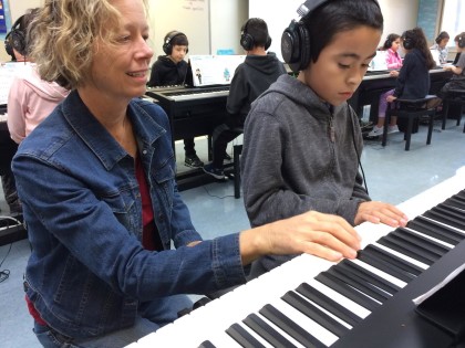 Music instructor Rebecca King works with Dunbar School student Bryan Vasquez Torres 